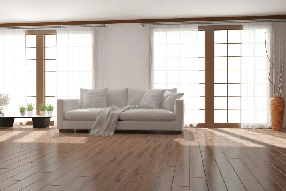 Detalle de un piso laminado en tonos claros que maximiza la luminosidad de la estancia.