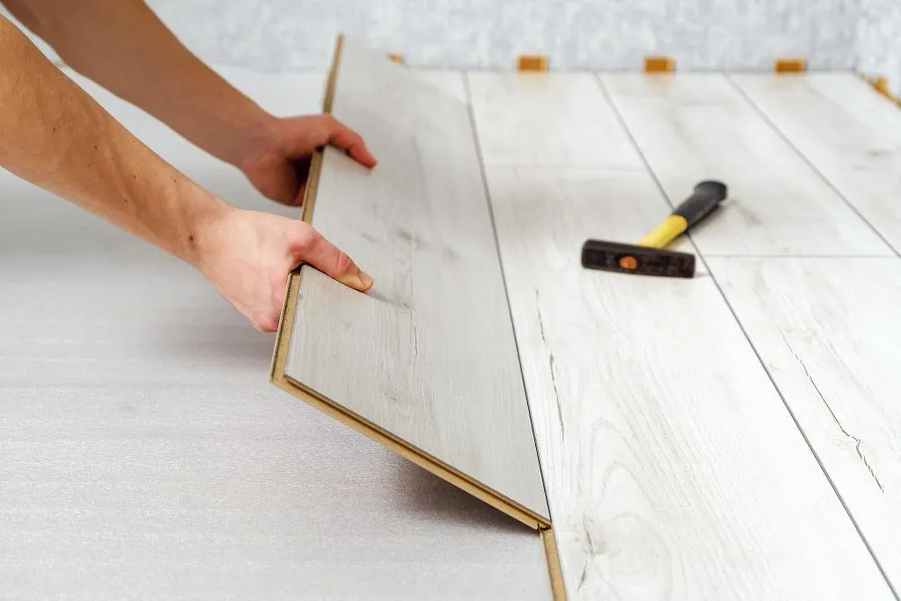 Proceso de instalación de un piso laminado que imita fielmente la textura de la madera real.